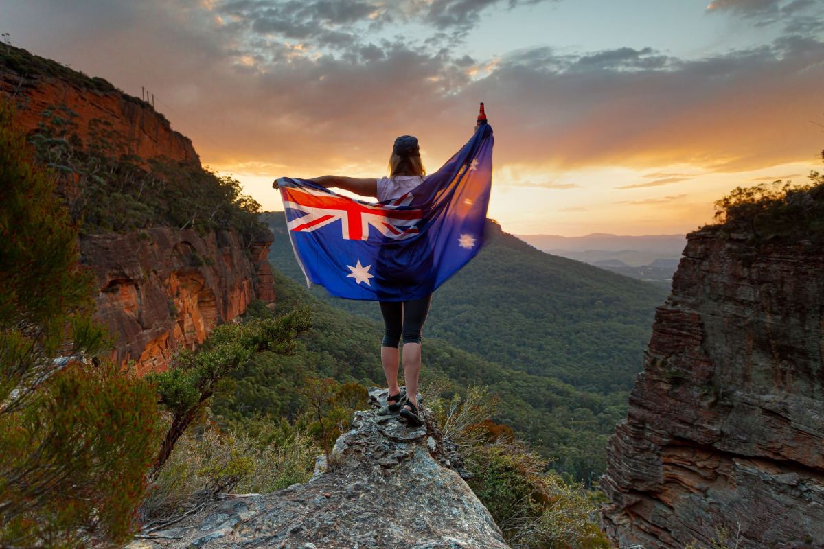 Hiker celebrates sunset wrapped in Australia flag